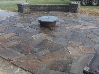 A fire pit is sitting on top of a stone patio.