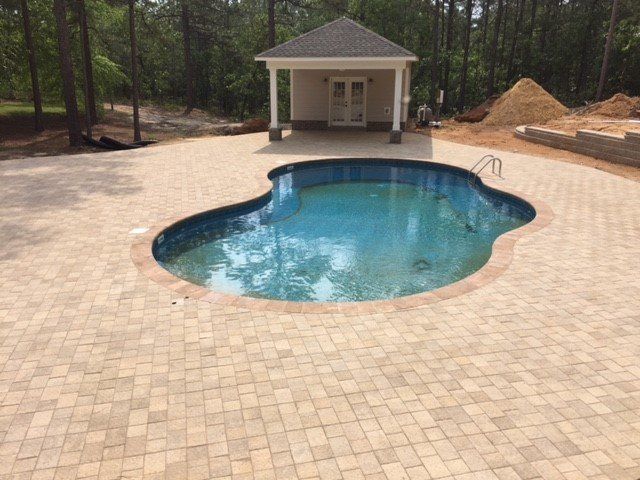 A large swimming pool with a gazebo in the background.