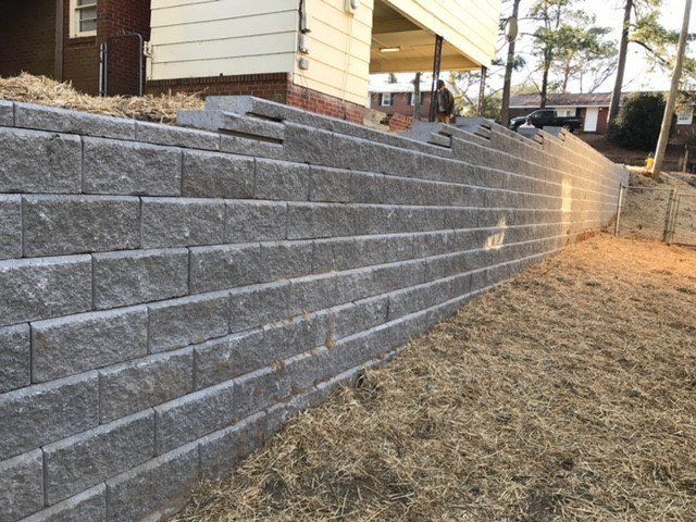 A brick wall is being built in front of a house.