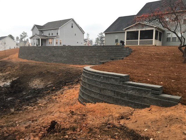 A large retaining wall is being built in front of a house.