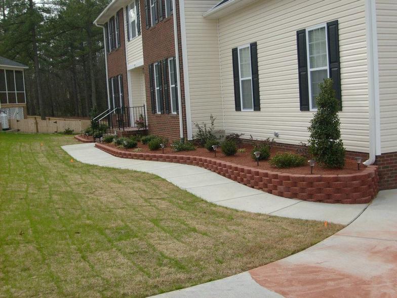 A house with a walkway and a lawn in front of it
