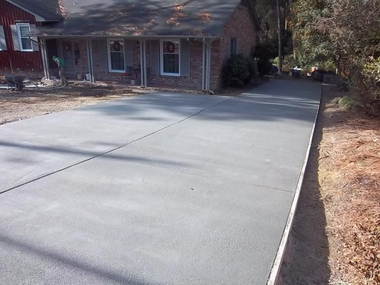 A brick house with a concrete driveway in front of it