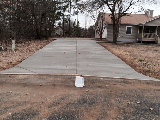 A concrete driveway is being built in front of a house.