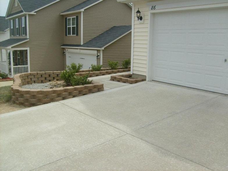 A driveway leading to a house with a white garage door