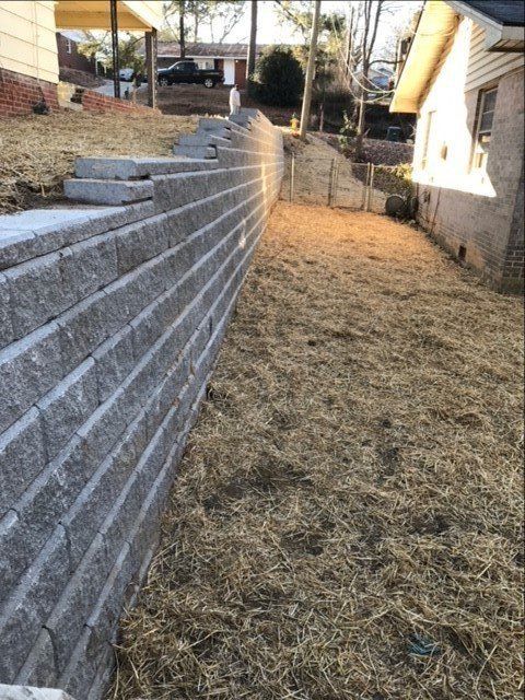 A brick wall is being built in the backyard of a house.