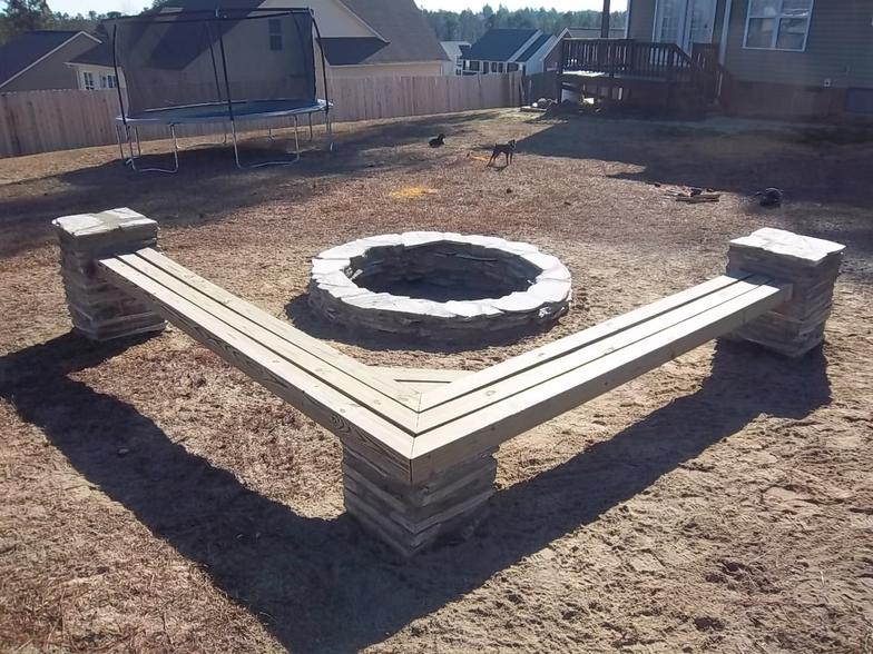 A fire pit with a bench in the middle of it