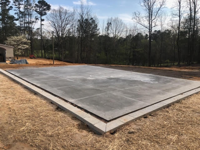 A large concrete slab is sitting on top of a dry grass field.
