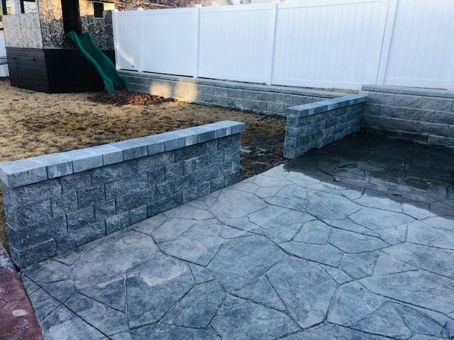 A patio with a brick wall and a slide in the background.