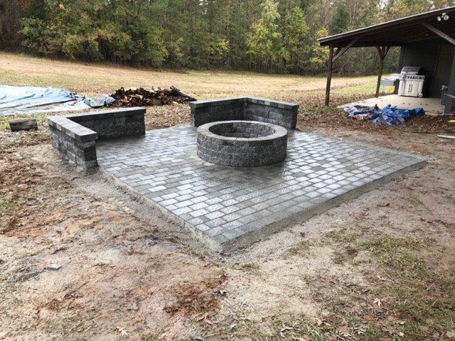 A fire pit is sitting on top of a brick patio.