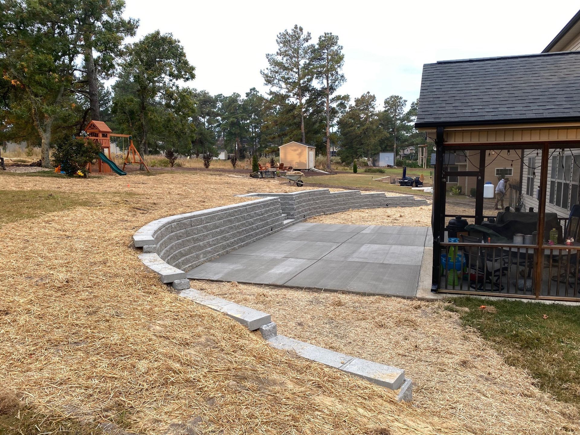 A patio is being built in the backyard of a house.