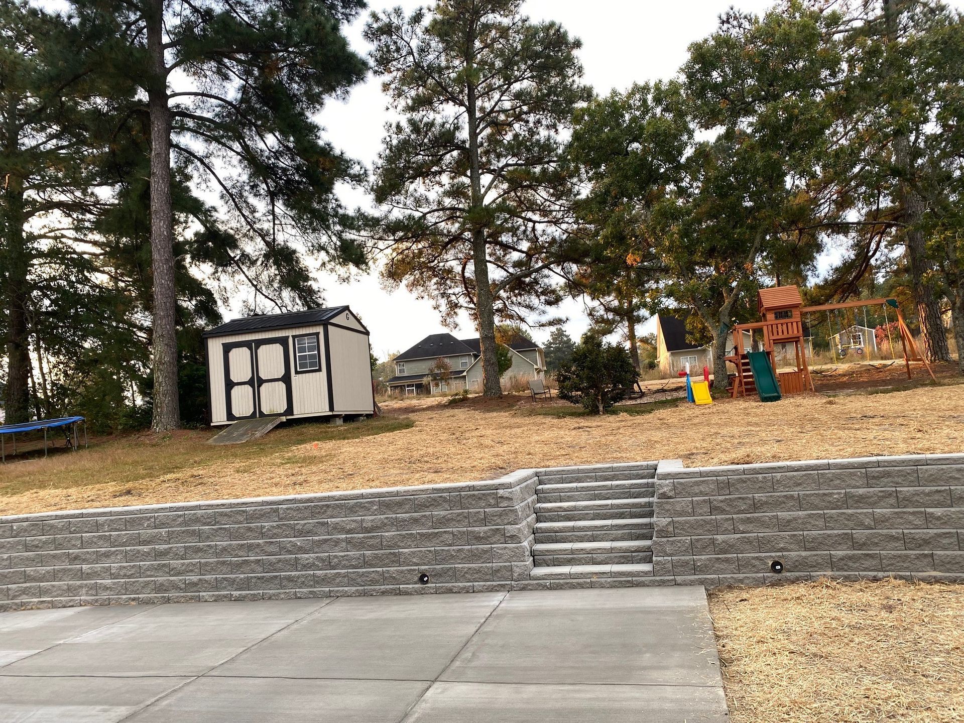 A shed is sitting on top of a hill next to a playground.