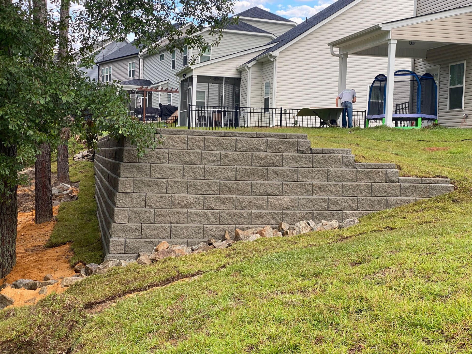 There is a brick wall in the backyard of a house.