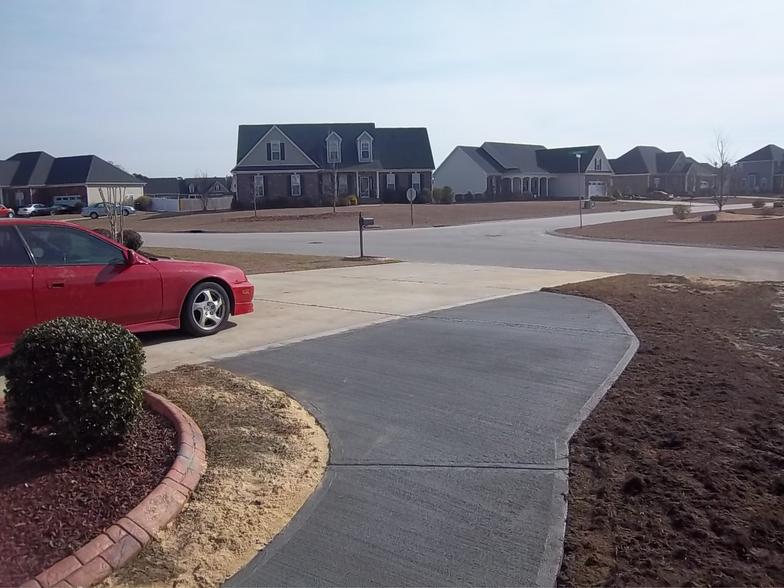 A red car is parked on the side of the road