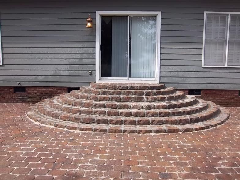 A set of brick steps leading up to a house with a sliding glass door