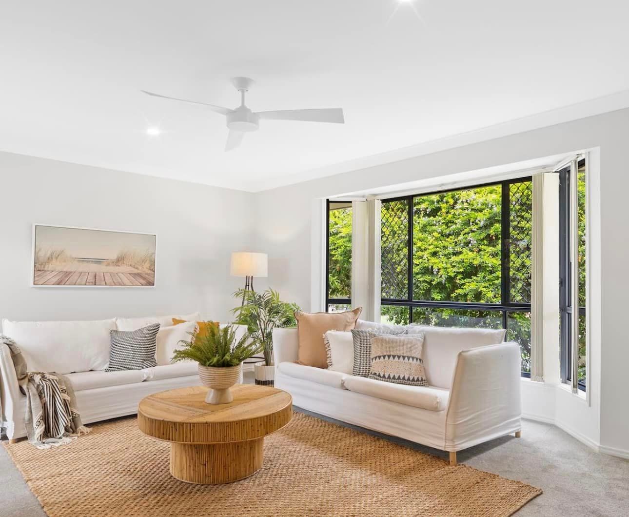 A living room with a couch, coffee table, and ceiling fan — Solo Reno Coatings In Gold Coast, QLD