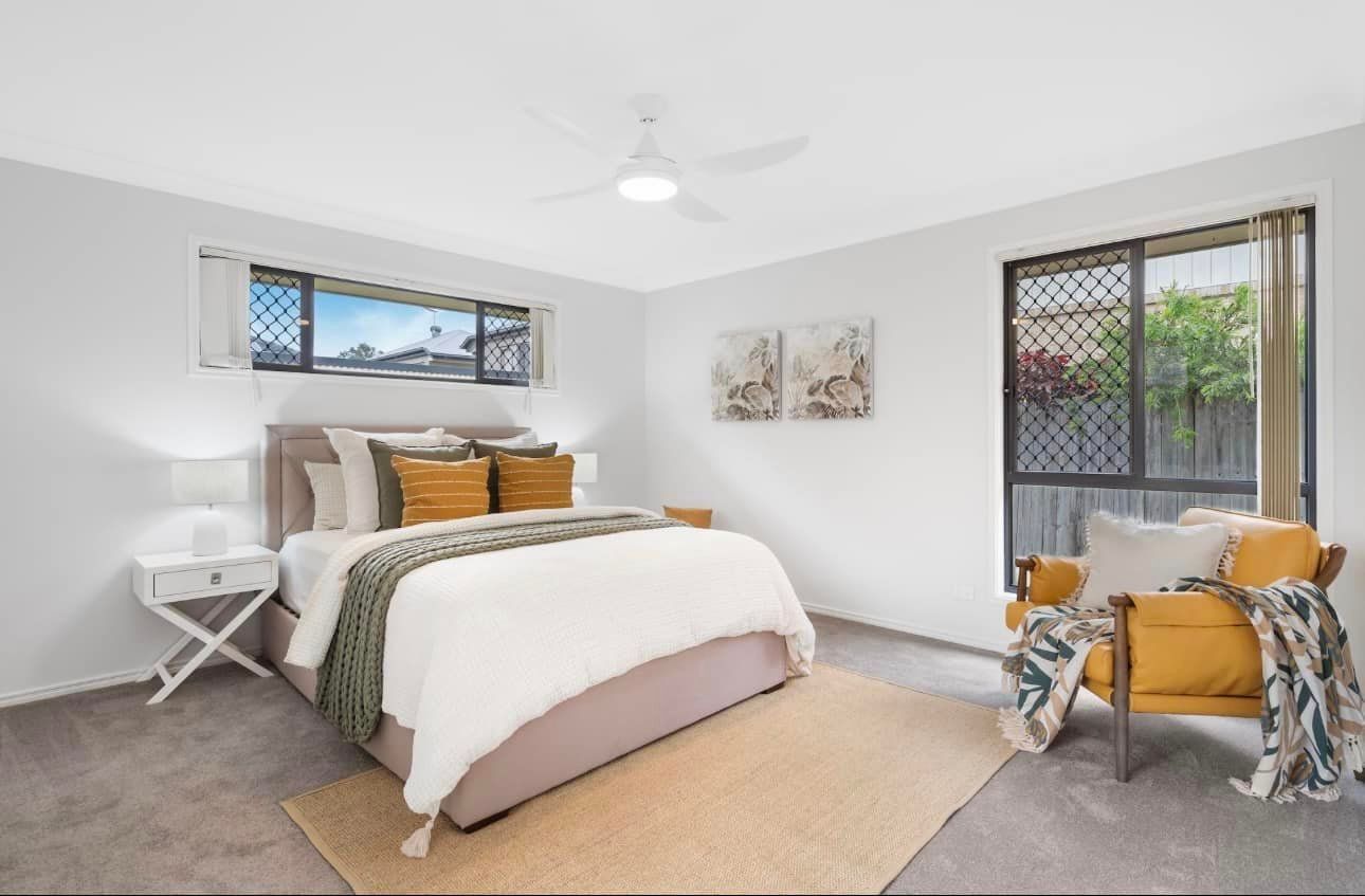 A bedroom with a bed, chair, nightstand and ceiling fan — Solo Reno Coatings In Gold Coast, QLD
