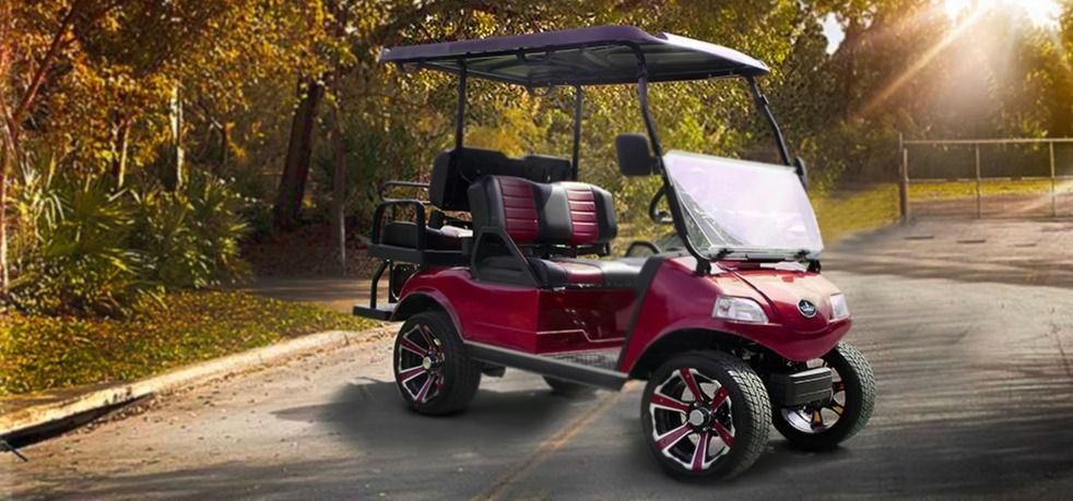A red golf cart is parked on the side of a road.
