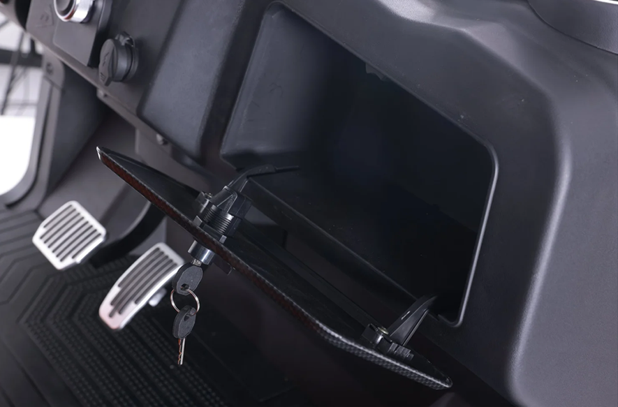 A black golf cart is parked in a dirt field.