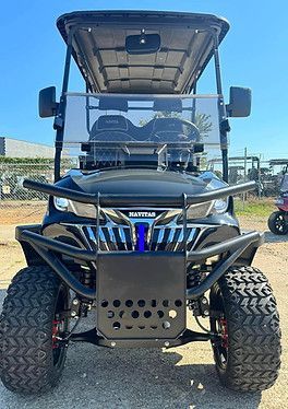 A black golf cart is parked in a parking lot.