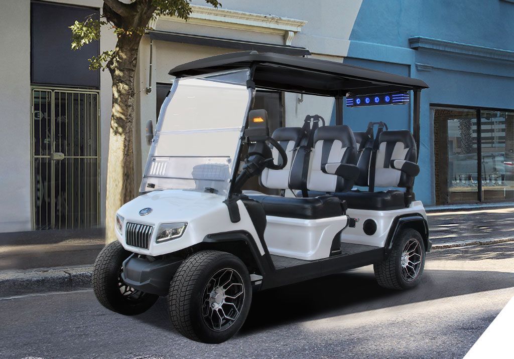 A white golf cart is parked on the side of the road in front of a building.