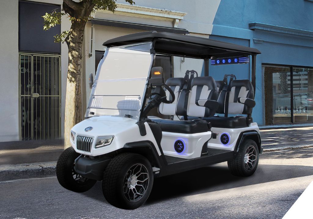 A white golf cart is parked on the side of the road in front of a building.