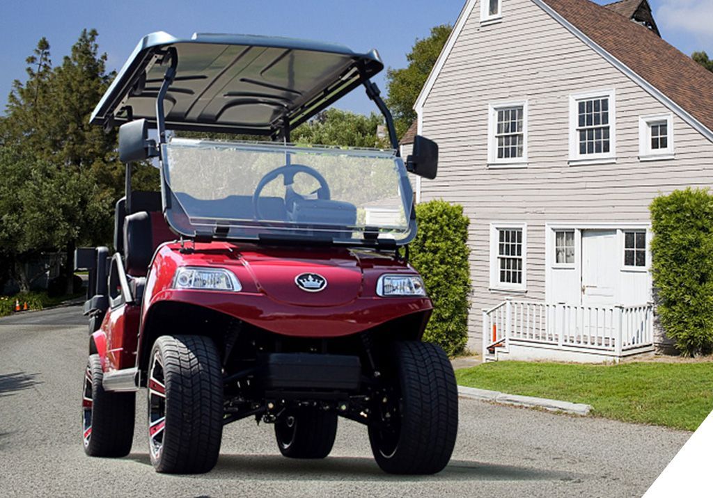 A red golf cart is parked in front of a house