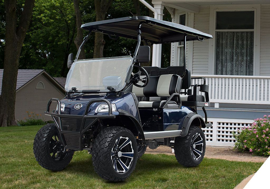 A blue golf cart is parked in front of a house.