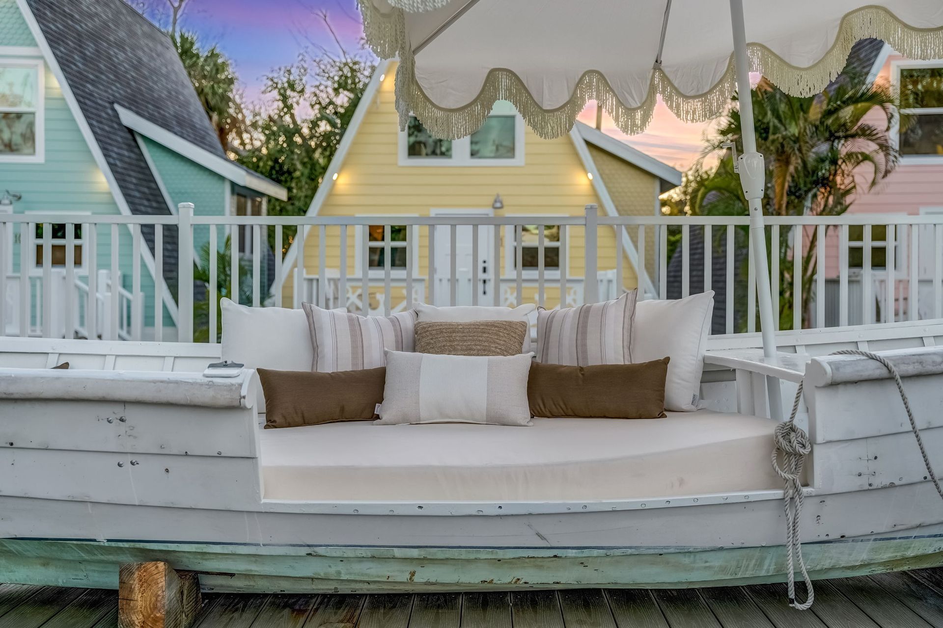 A row of houses are lit up at night with palm trees in the foreground