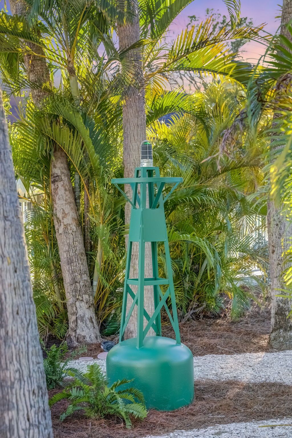 A swimming pool in front of a yellow house with a white fence
