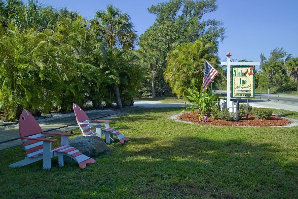 A couple of chairs are sitting in the grass in front of a sign.