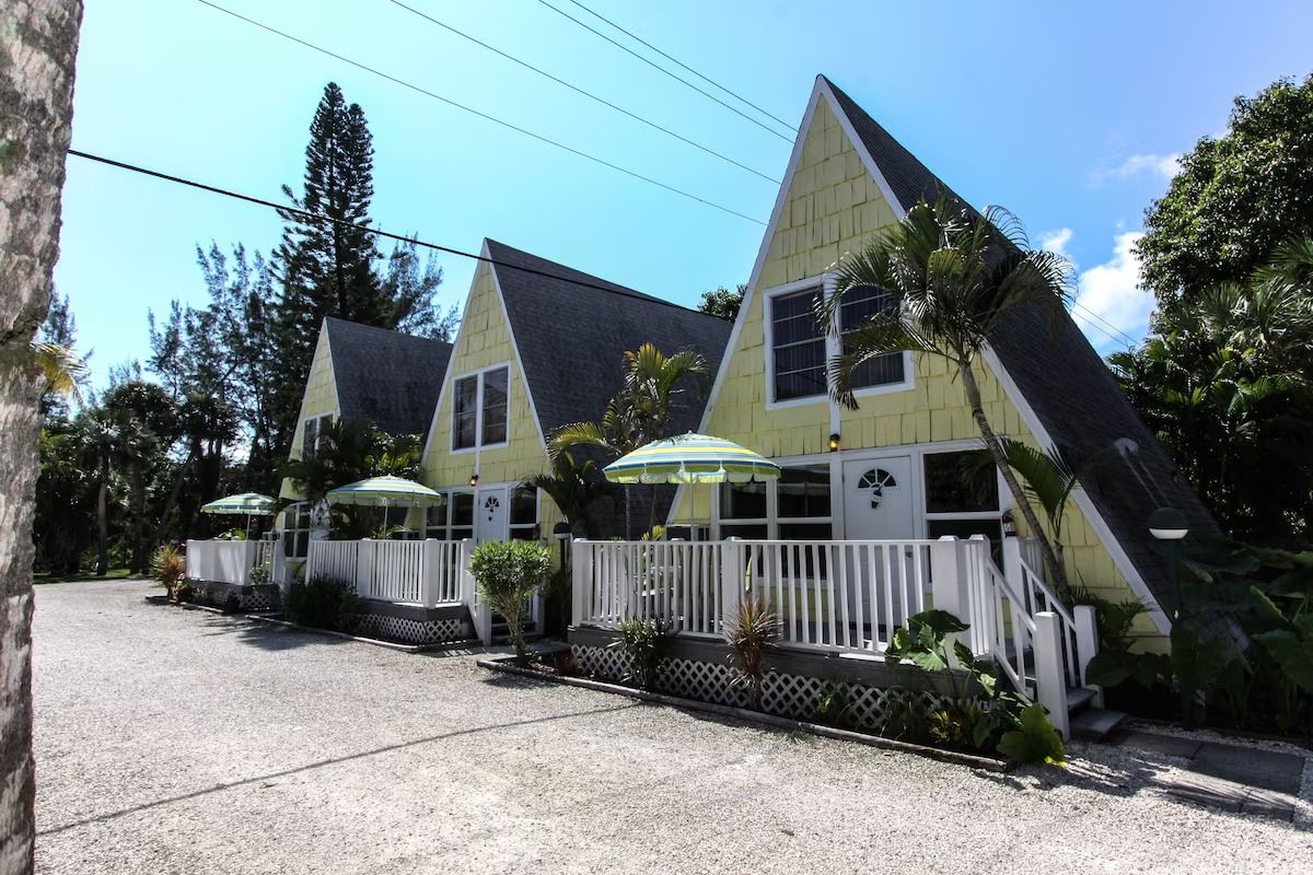 A row of yellow houses with umbrellas in front of them
