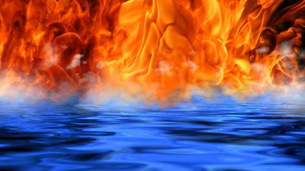 Fiery flames erupt above a blue water surface, with smoke wisps.
