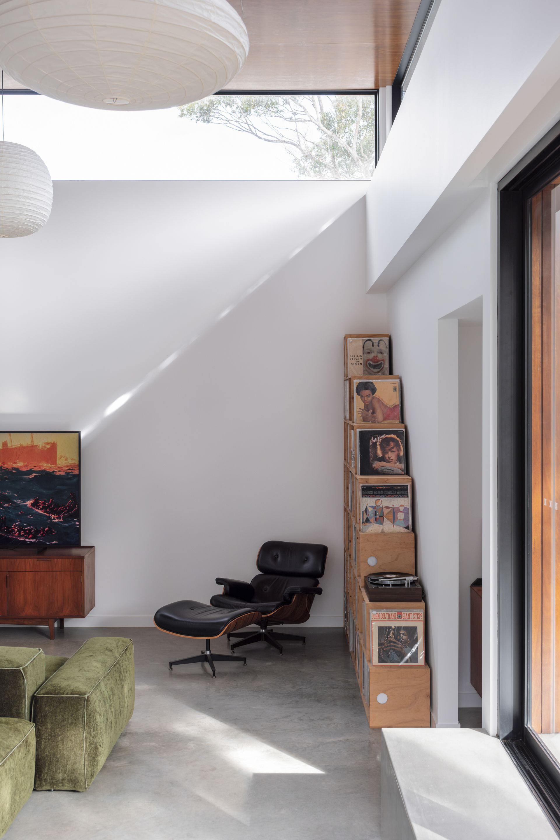 A Living Room With a Chair and a Stack of Records — DeBu Studios In Southern Sydney, NSW