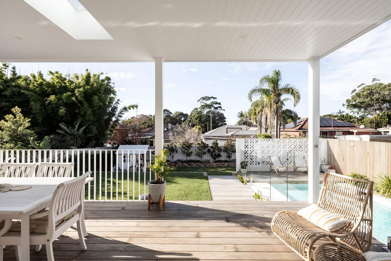 A Patio With A Table And Chairs And A Swimming Pool In The Background — DeBu Studios In Russell Vale, NSW