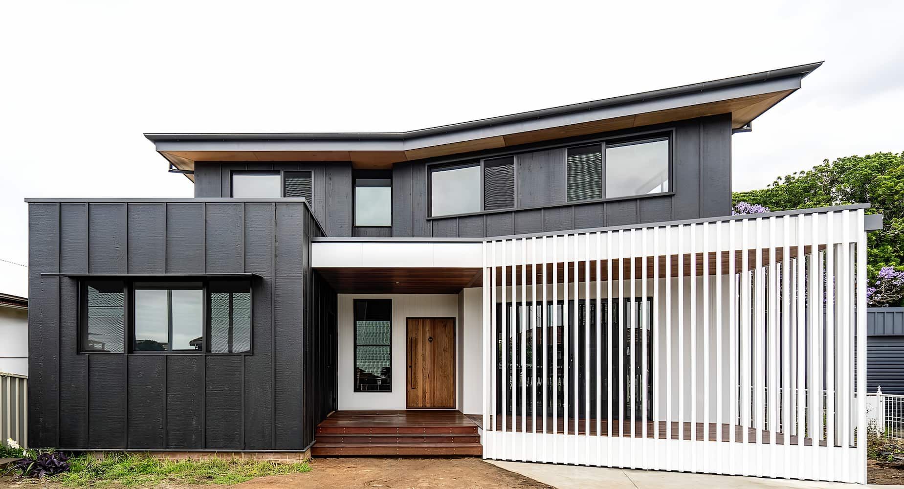 A Large Black And White House With A White Fence In Front Of It — DeBu Studios In Russell Vale, NSW