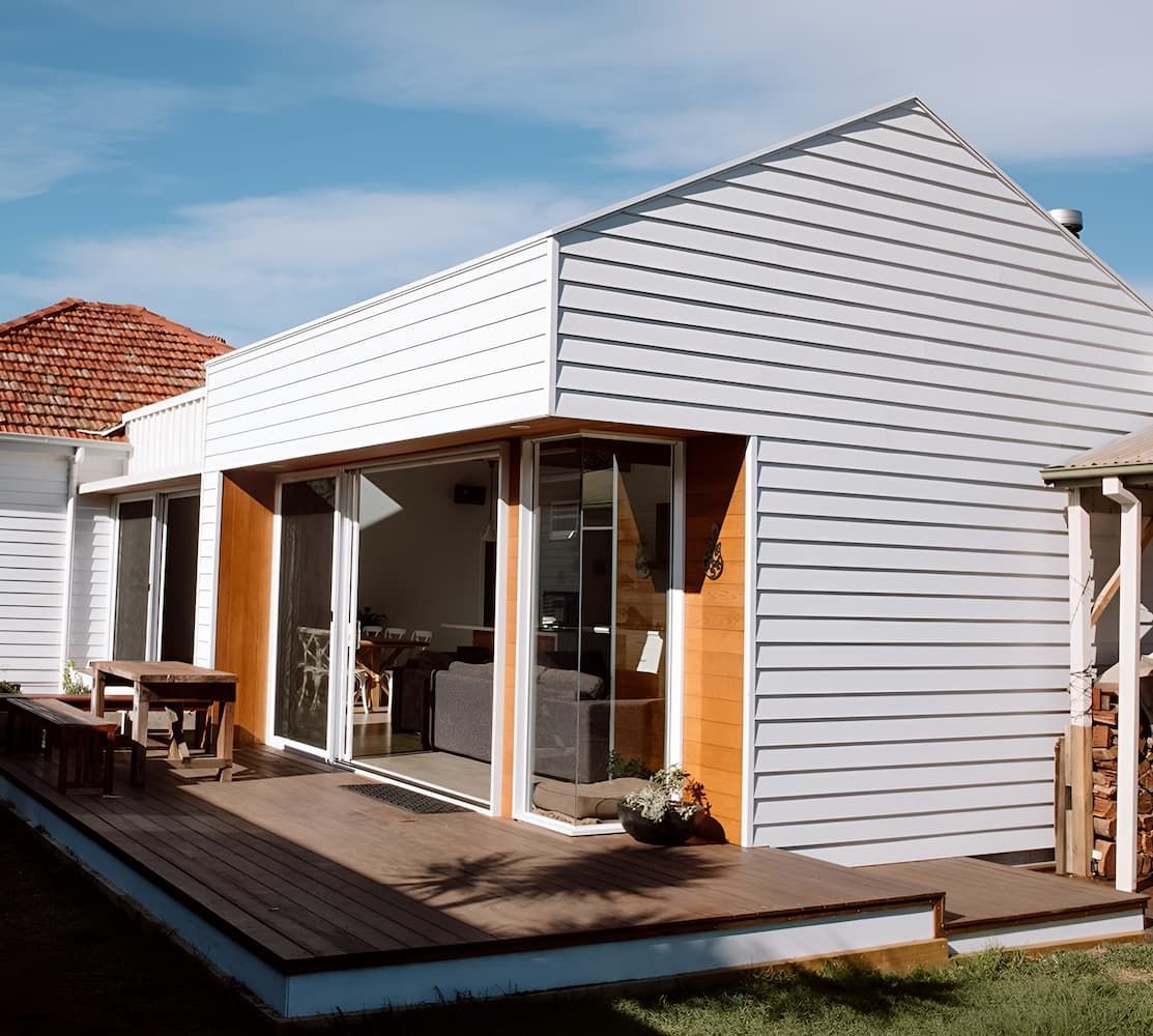 A White House With A Wooden Deck In Front Of It — DeBu Studios In Russell Vale, NSW