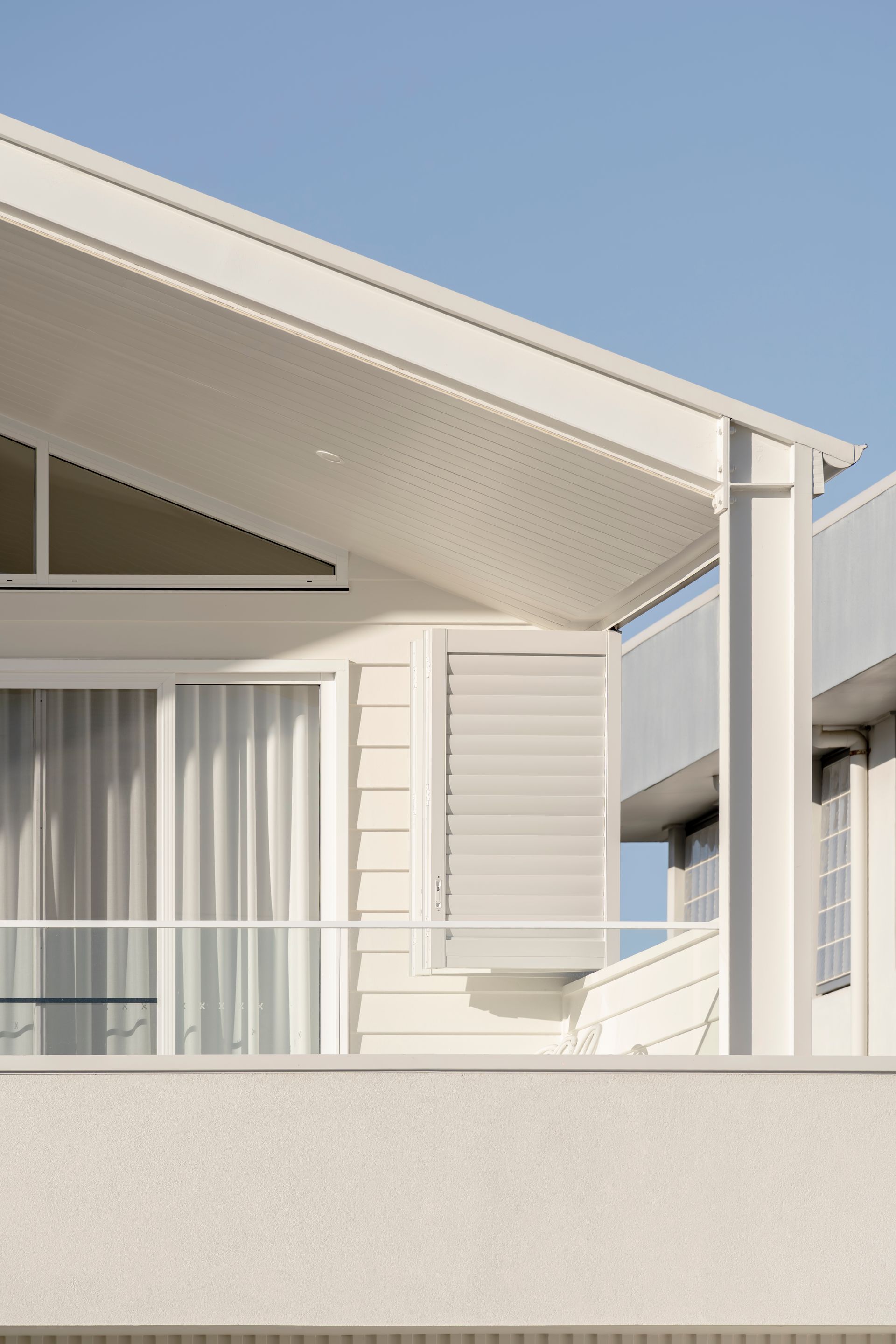 A white house with a balcony and a blue sky in the background — DeBu Studios In Southern Sydney, NSW