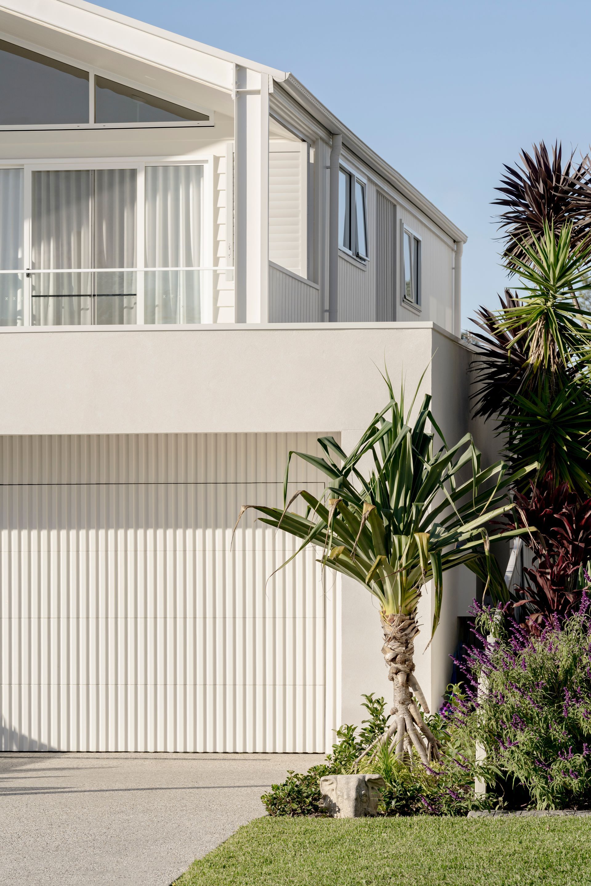 A white house with a garage and a palm tree in front of it — DeBu Studios In Southern Sydney, NSW