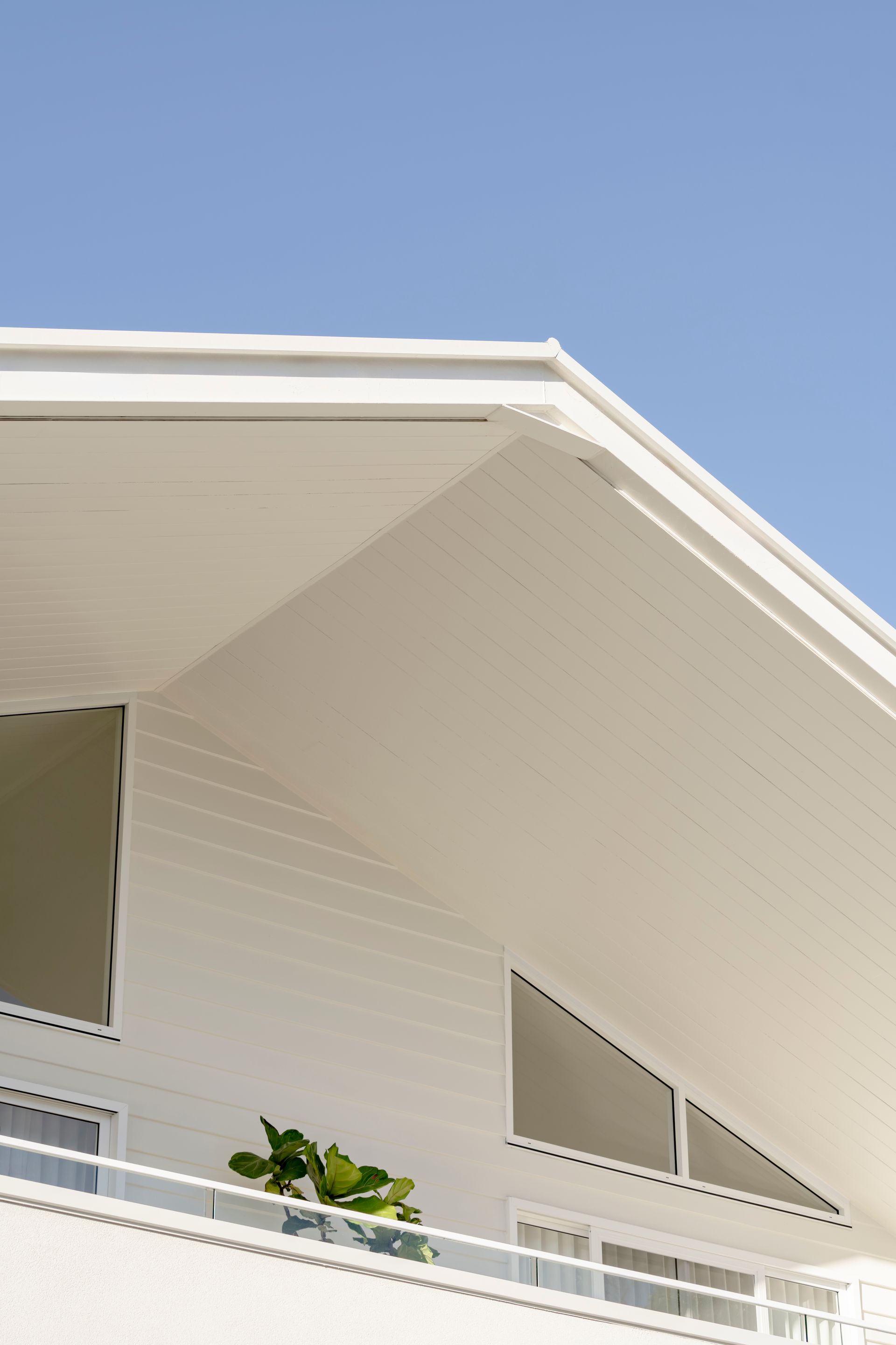 A white house with a balcony and a blue sky in the background — DeBu Studios In Southern Sydney, NSW