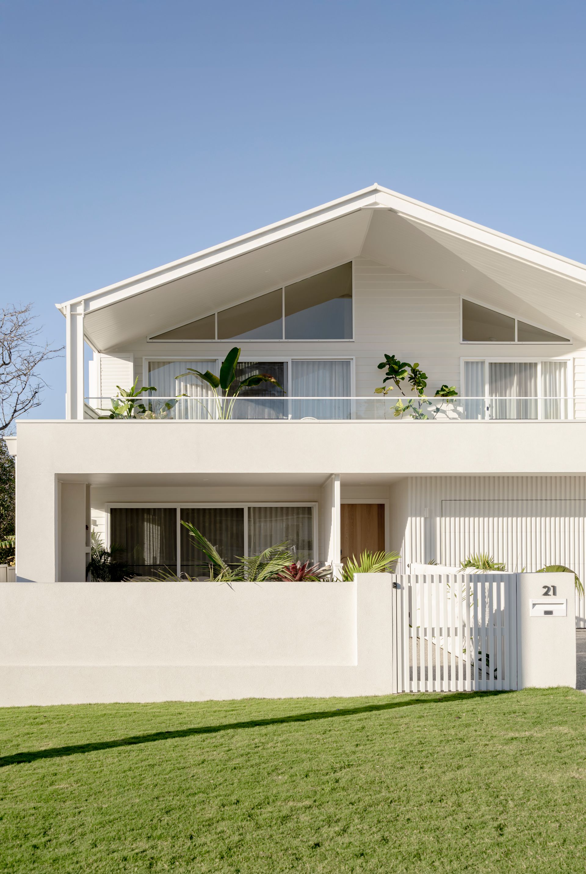 A white house with a balcony and a fence in front of it — DeBu Studios In Southern Sydney, NSW