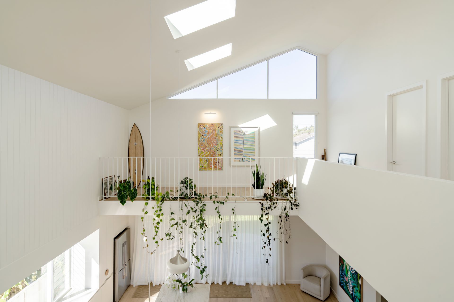 A white house with a balcony and a surfboard on the second floor — DeBu Studios In Southern Sydney, NSW