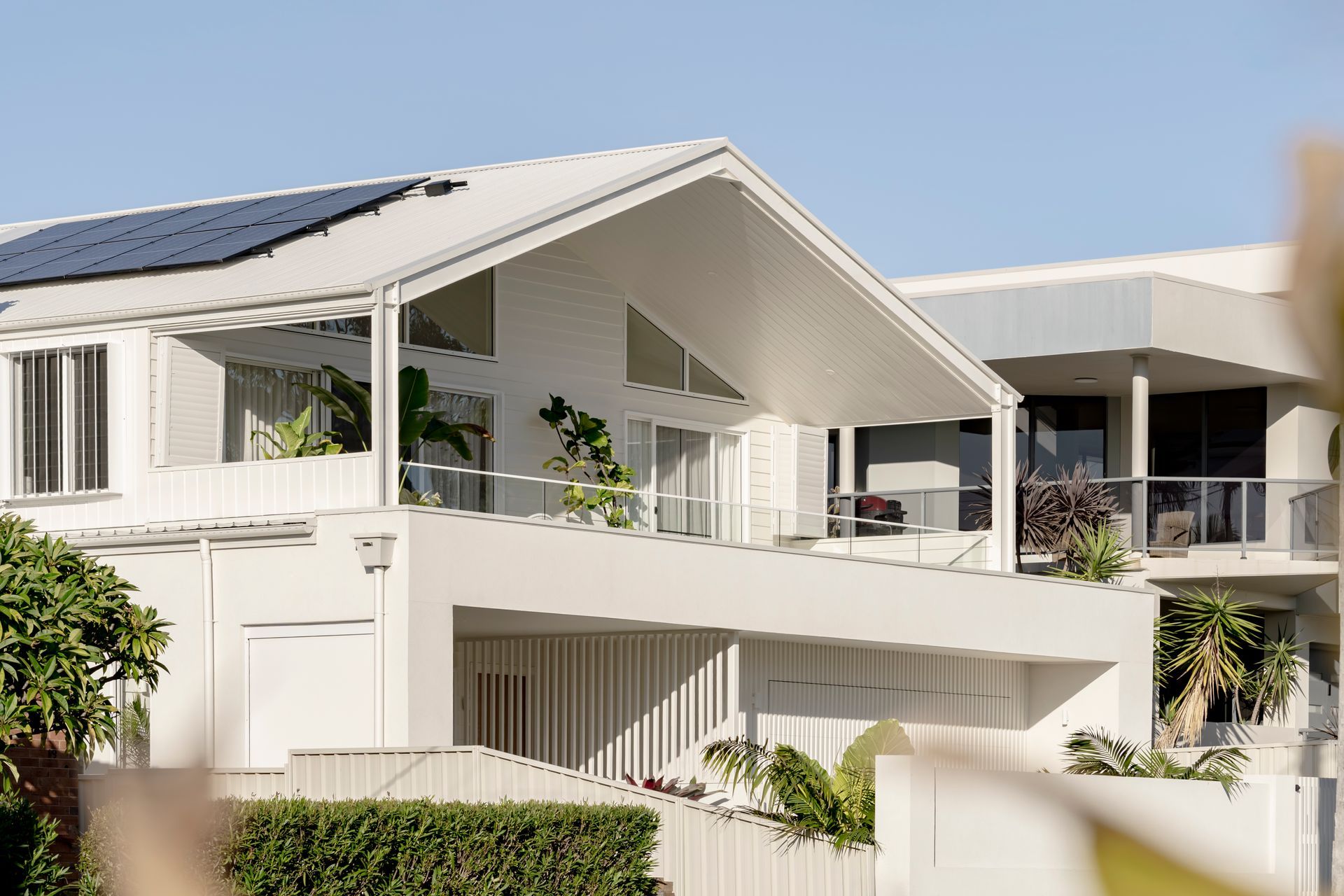 A large white house with solar panels on the roof — DeBu Studios In Southern Sydney, NSW