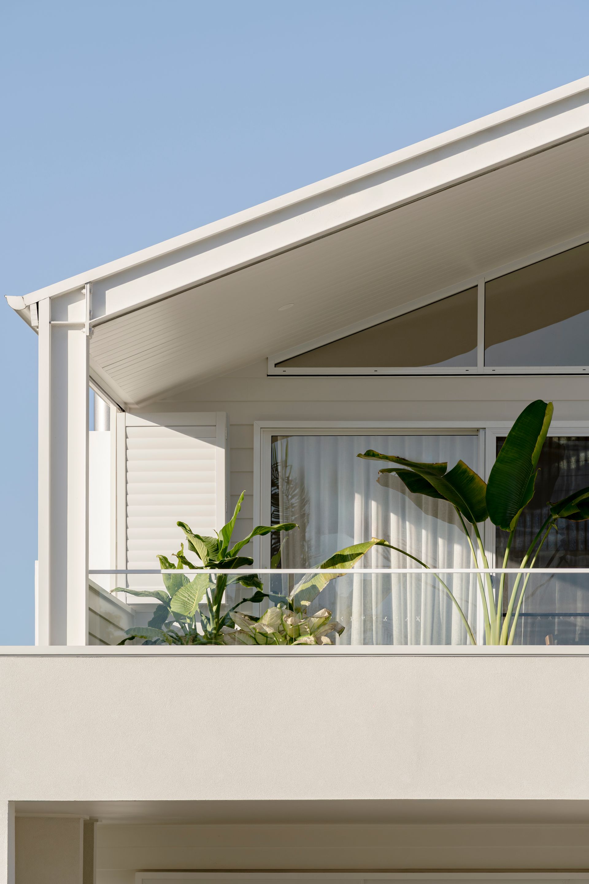 A white house with a balcony and plants on it — DeBu Studios In Southern Sydney, NSW