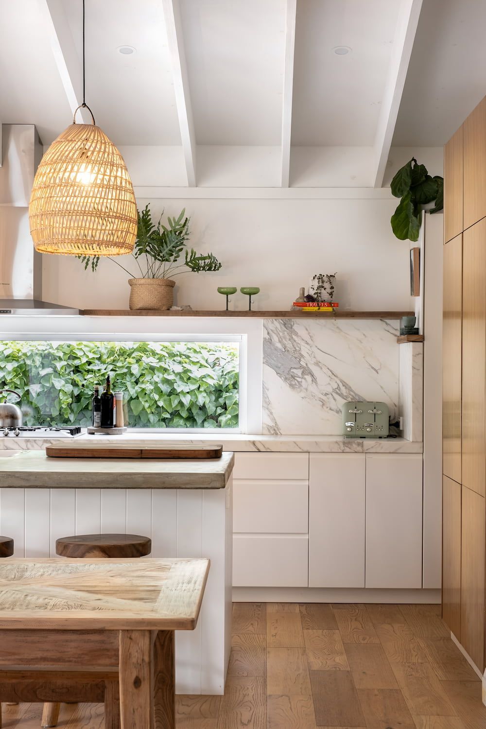 A Kitchen With White Cabinets, A Wooden Table, And A Window — DeBu Studios In Russell Vale, NSW