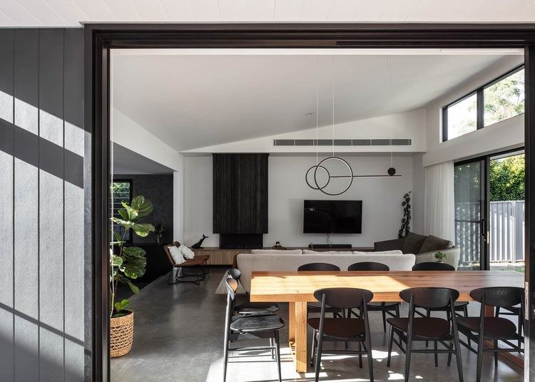 A Living Room With a Dining Table and Chairs and a Flat Screen Tv — DeBu Studios In Russell Vale, NSW