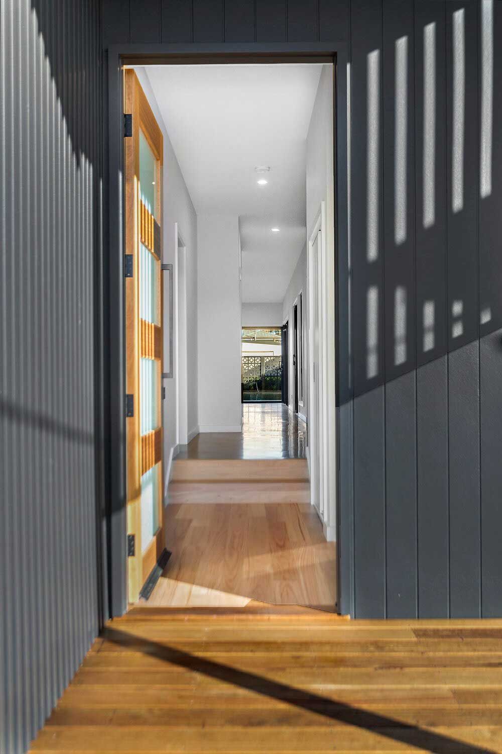 A Hallway With a Door Open and a Wooden Floor — DeBu Studios In Russell Vale, NSW