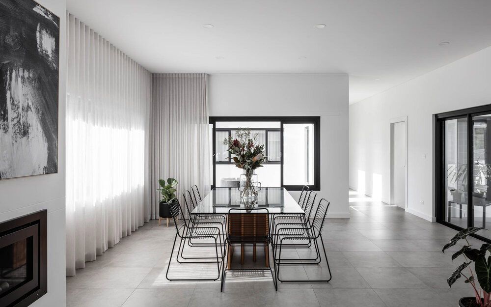 A Dining Room With a Long Table and Chairs and a Fireplace — DeBu Studios In Russell Vale, NSW