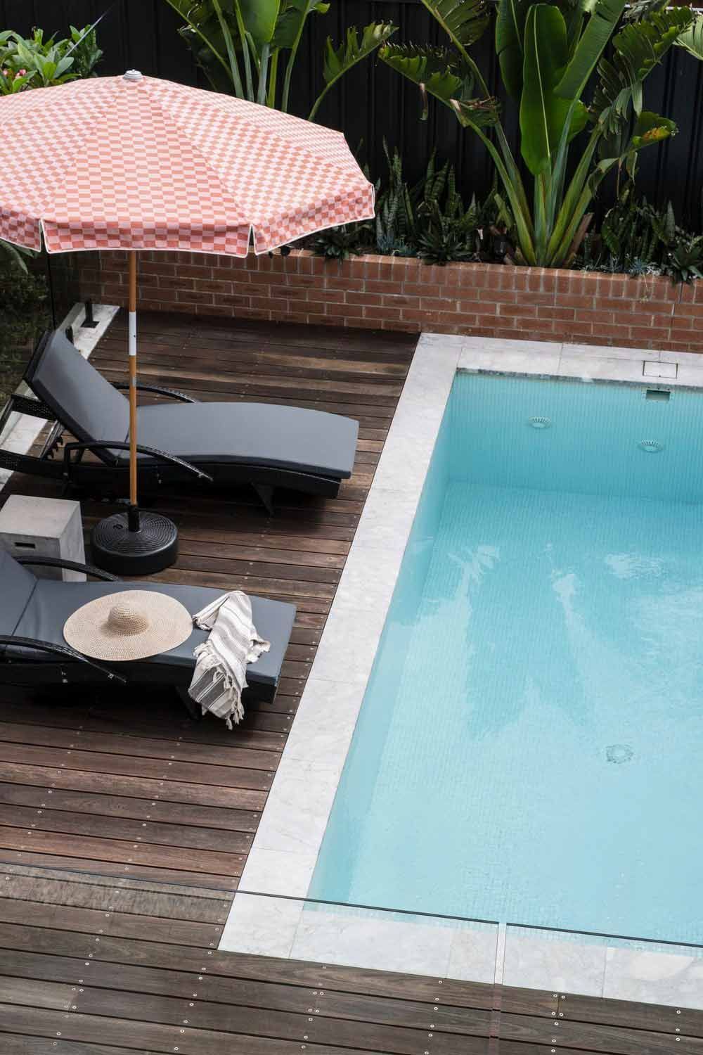 A Swimming Pool With Chairs and an Umbrella on the Deck — DeBu Studios In Russell Vale, NSW