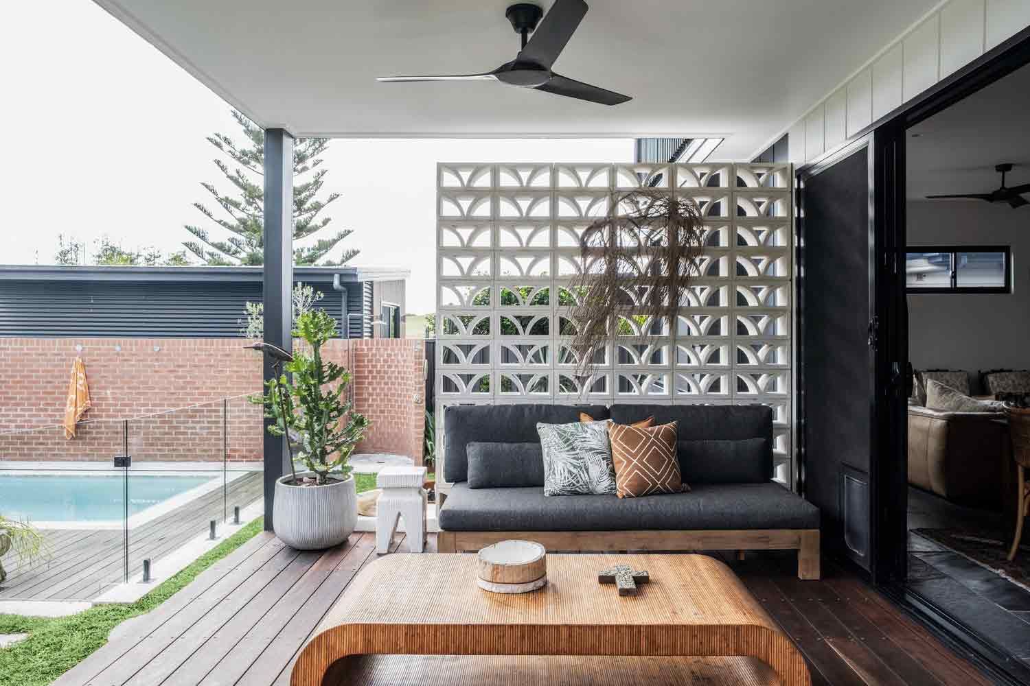 A Patio With a Couch, Coffee Table, and a Ceiling Fan — DeBu Studios In Russell Vale, NSW