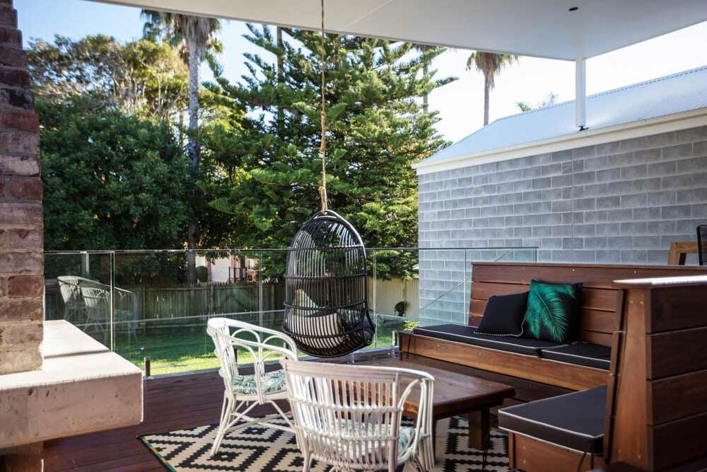 A Patio With Chairs, a Table, and a Hanging Chair — DeBu Studios In Russell Vale, NSW
